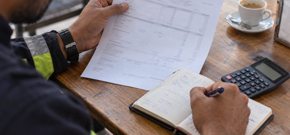 Un lavoratore confronta una busta paga con il proprio registro delle ore.
